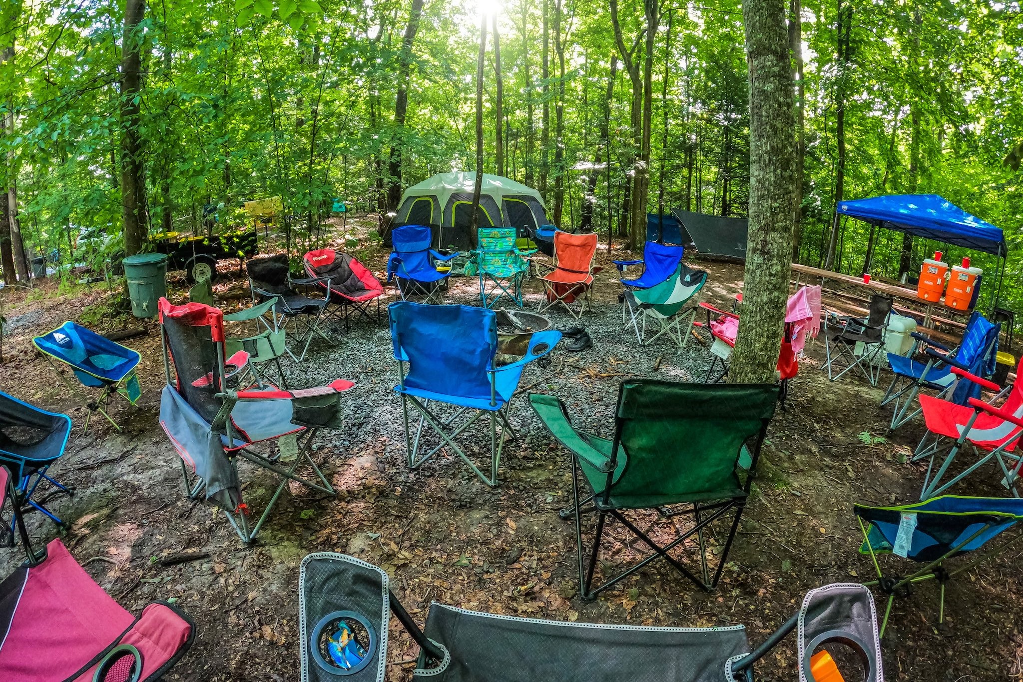 a campsite in the new river gorge with tents, chairs, and picnic tables
